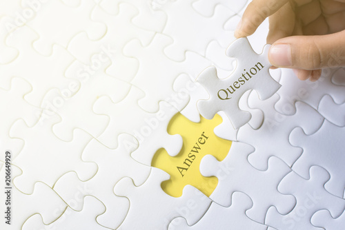 hand holding question and answer word on jigsaw puzzle. q&a, faq and question concept