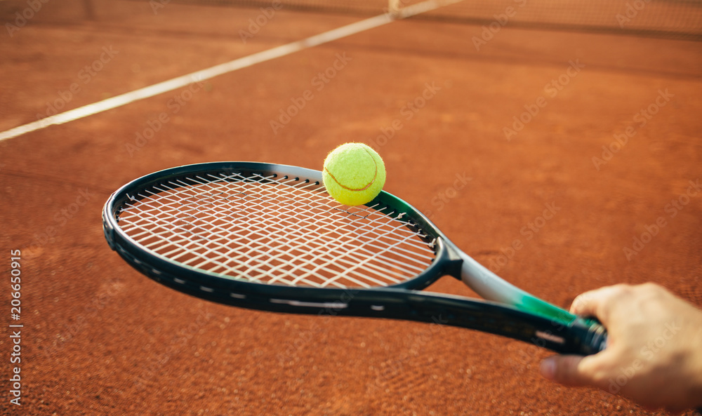 Tennis racket and ball on the clay court