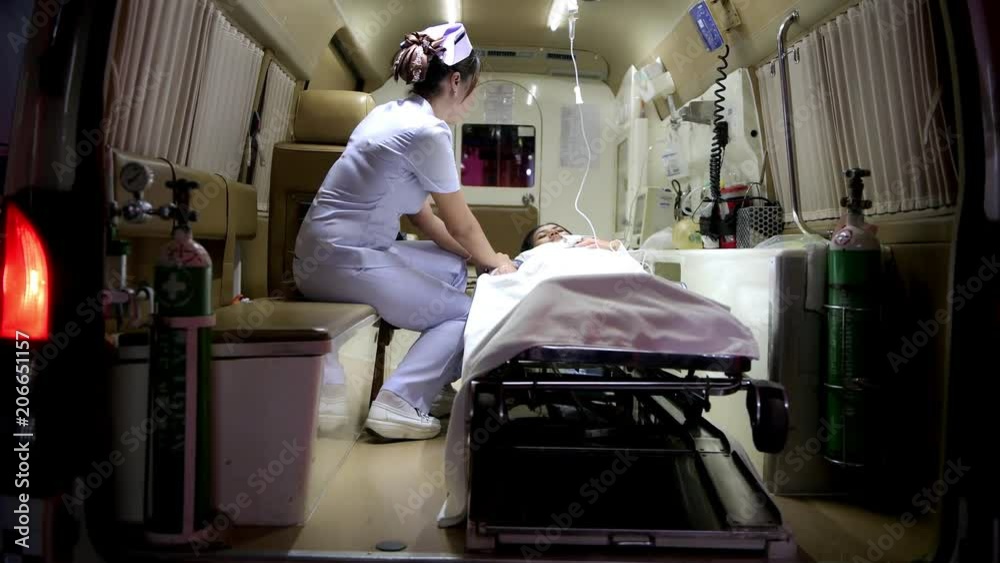 Accident victim inside ambulance at night being treated by nurse ...