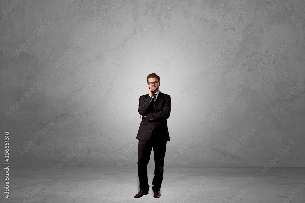 Alone handsome businessman standing in a dark empty room Alone handsome businessman standing in a dark empty room