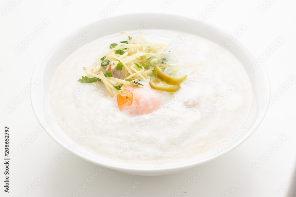 Asian congee with minced pork and egg in white bowl.