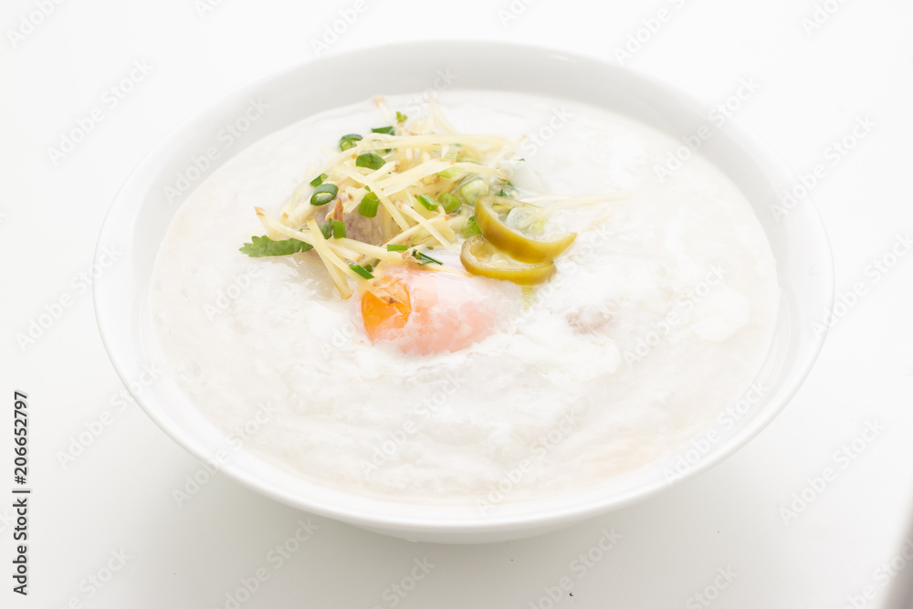 Asian congee with minced pork and egg in white bowl. Asian congee with minced pork and egg in white bowl.
