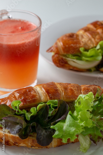 croissant with salad, cheese and tomatoes on wooden background.