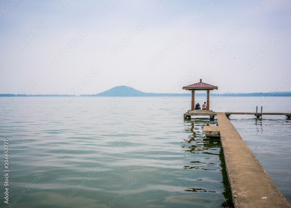 Pavilion at Donghu east lake and Moshan hill in background in Wuhan Hubei China Pavilion at Donghu east lake and Moshan hill in background in Wuhan Hubei China