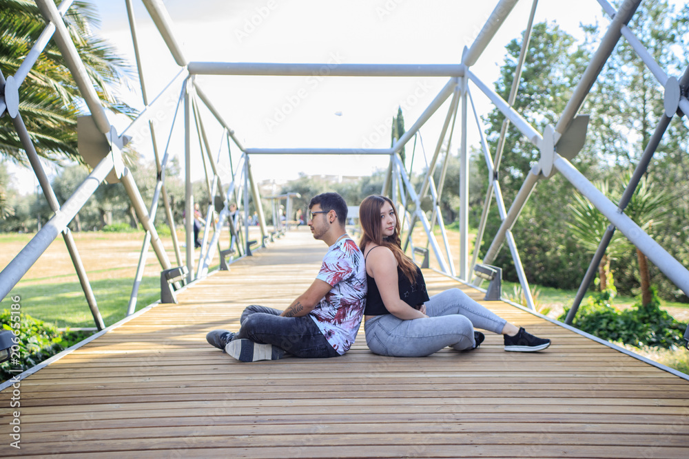 pareja sentada en un puente espalda contra espalda pareja sentada en un puente espalda contra espalda