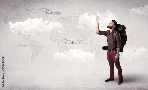Handsome young man standing with a backpack on his back and planes in front of a world map as a background  © ra2 studio