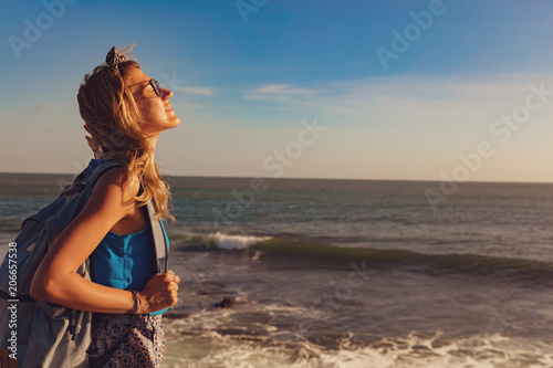 Girl enjoying the tropical sunset on the ocean shore.