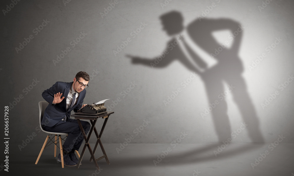 Fototapeta premium Little man working and a big shadow arguing with him 