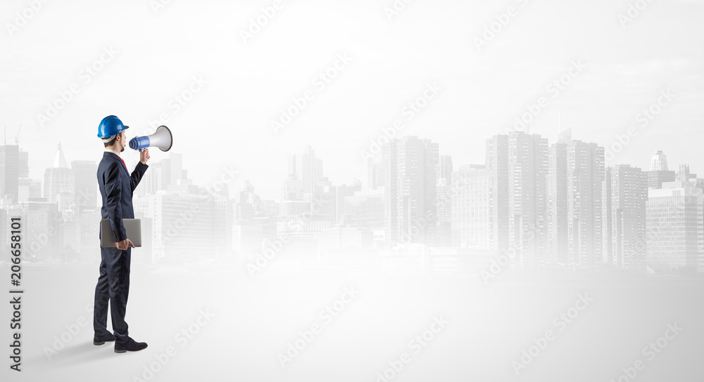 Young supervisor architect standing and looking at a big city panorama
Young supervisor architect standing and looking at a big city panorama