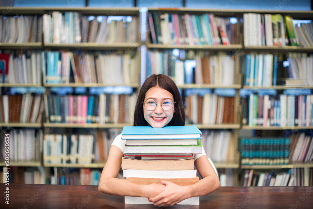 education, school and people concept - Cheerful university students with happy read a book and report in Library.; Asia university. education, school and people concept - Cheerful university students with happy read a book and report in Library.; Asia university.