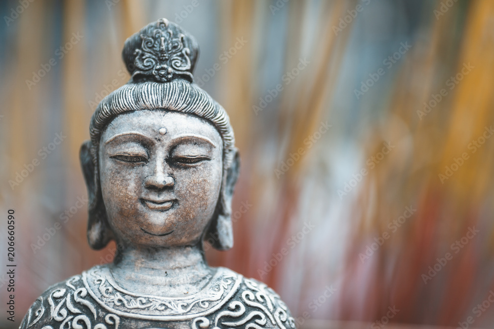 Buddha statue in front of incense sticks