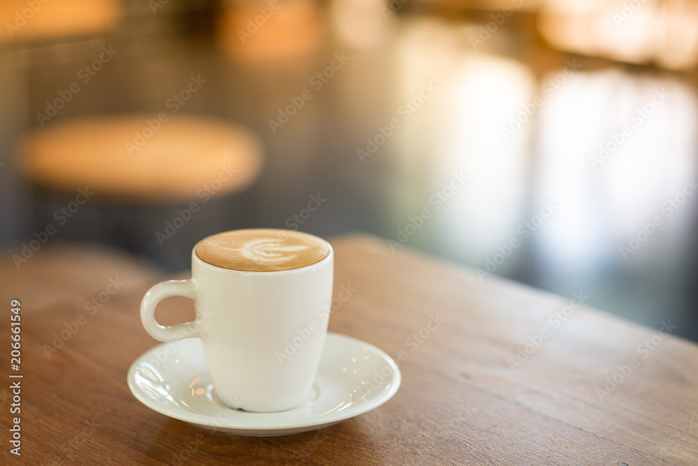 Hot Latte is placed on a wooden table in a cafe. Wait for customers to drink. To refresh the morning.