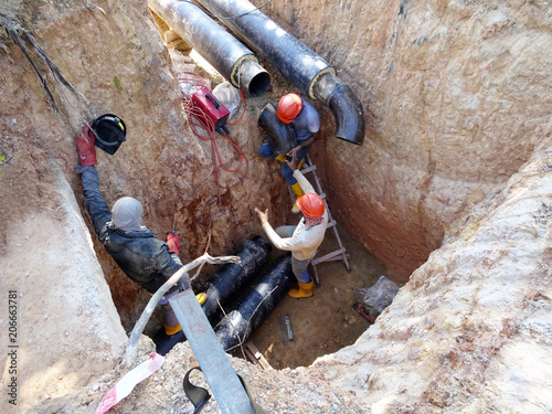 Construction workers risky their lives working inside deep trenches to install underground services pipe. Not following standard safety procedure. 