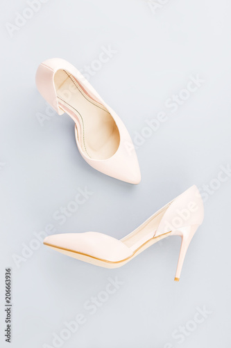 Pale pink female shoes close up on gray background.