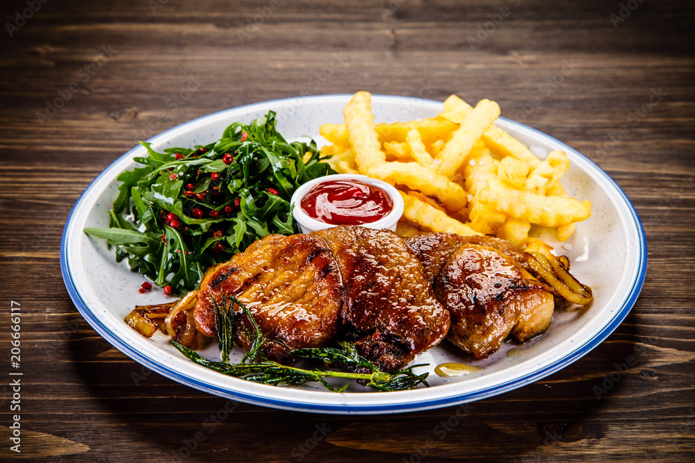 Grilled beefsteak with french fries and vegetable salad Grilled beefsteak with french fries and vegetable salad