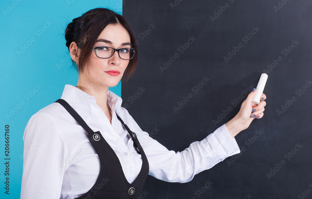 People and education. Teacher writing on math equation on blackboard during lesson. People and education. Teacher writing on math equation on blackboard during lesson.