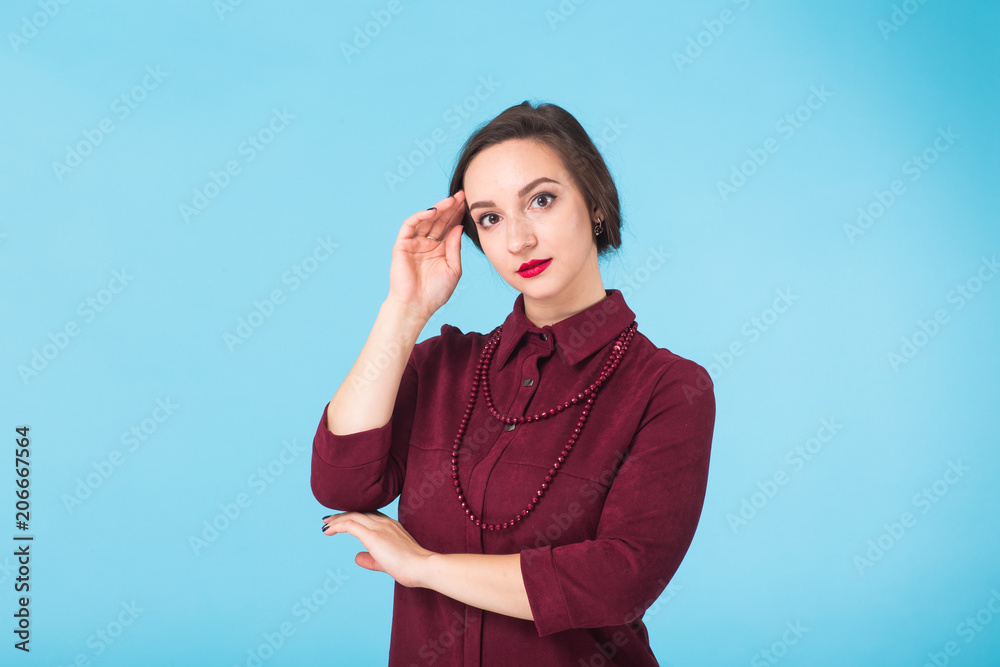 Beauty fashion female portrait. Smiling young woman on blue wall background. Beauty fashion female portrait. Smiling young woman on blue wall background.