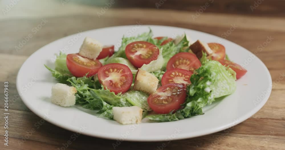 Slow motion closeup adding croutons to caesar salad Slow motion closeup adding croutons to caesar salad