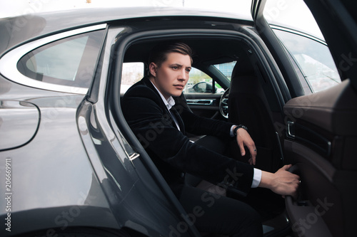 Be smart and intelligent! A handsome serious young businessman sitting into his comfortable new car and going to the office. © stacestock