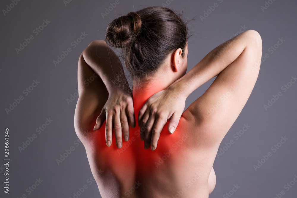 Neck pain, woman with backache on gray background Neck pain, woman with backache on gray background