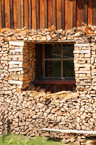 Brennholz als Vorrat vor einem Fenster aufgestapelt