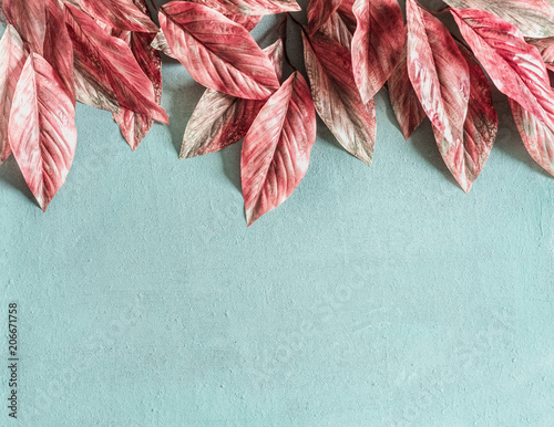 Beautiful pink leaves border on pastel blue background , top view, flat lay. Nature concept