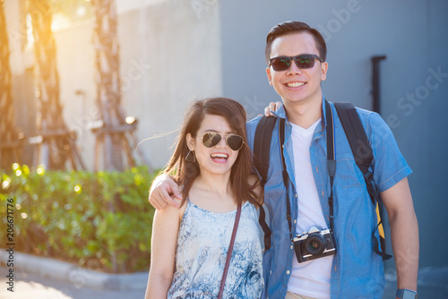 Young asian tourist couple smiling and walking on the street