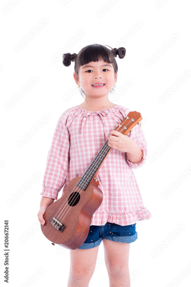 Little asian girl holding ukulele and smiles over white background Little asian girl holding ukulele and smiles over white background
