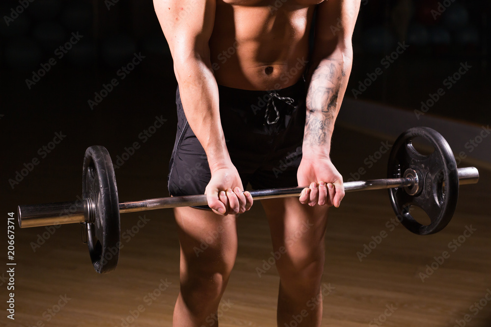 Handsome power athletic man with barbell. Strong bodybuilder with six pack, perfect abs, shoulders, biceps, triceps and chest Handsome power athletic man with barbell. Strong bodybuilder with six pack, perfect abs, shoulders, biceps, triceps and chest