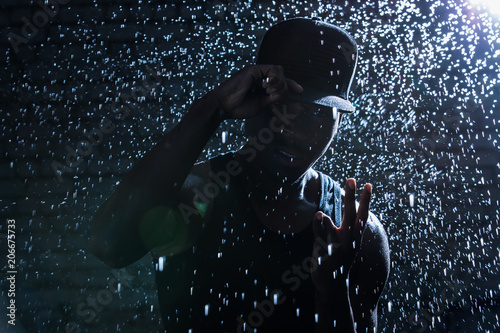 Rapper black man hooligan under rain