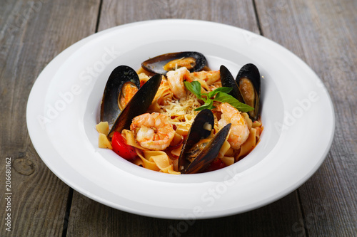 Delicious Italian seafood pasta. Appetizing hot fettuccine with clams, prawns, seafood cocktail. Mediterranean cuisine, banquet, restaurant menu food photo, dining concept