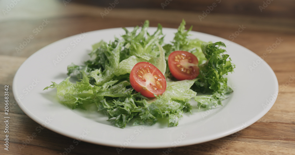 closeup adding tomatoes to caesar salad closeup adding tomatoes to caesar salad