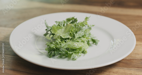 frillis salad leaves falling into white bowl