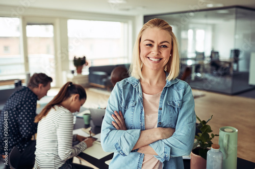Young businesswoman smiling with coworkers sitting in the backgr