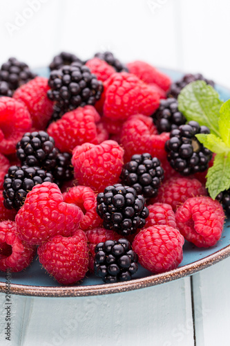 Fresh raspberries in a plate on a  vintage background.