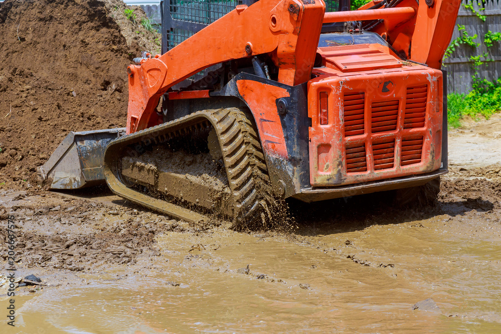Wheel loader Excavator with backhoe unloading earth at eathmoving works construction site quarry Wheel loader Excavator with backhoe unloading earth at eathmoving works construction site quarry