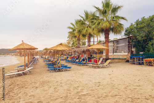 Alikanas, Zakynthos Island, Greece – September 28, 2017: Sunbeds, umbrellas and palms on the Alikanas beach, Zakynthos Island, Greece. © djevelekova