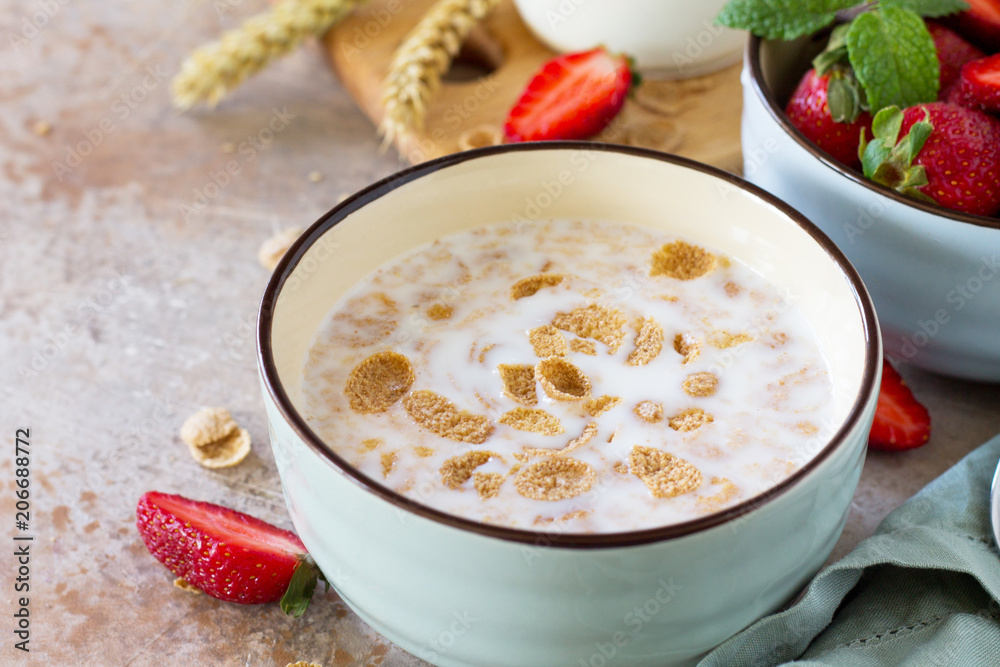 Healthy breakfast close-up - whole grain flakes, milk and fresh strawberries on stone or slate background. The concept of nutrition health. Healthy breakfast close-up - whole grain flakes, milk and fresh strawberries on stone or slate background. The concept of nutrition health.
