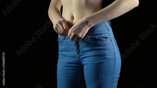 Young woman undressing blue jeans photo