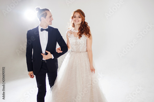 Positive young couple laughing and dancing together. The couple in the Studio a light background.