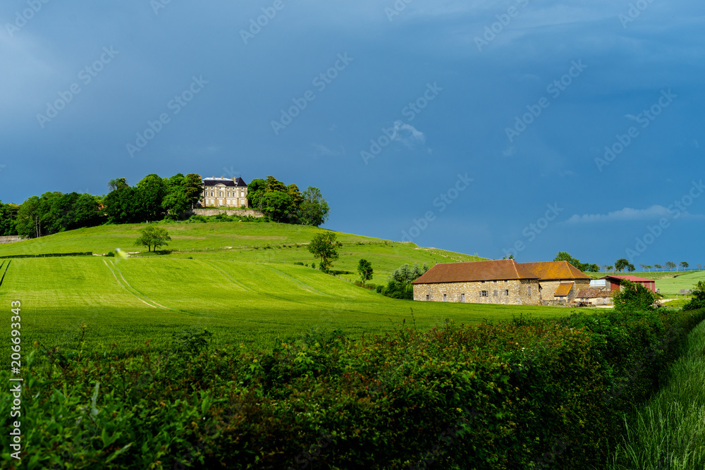 F, Burgund, dramatische Gewitterstimmung im Frühjahr bei Château d'Uxelles mit grünen Weiden, Schloß und dunklem Himmel