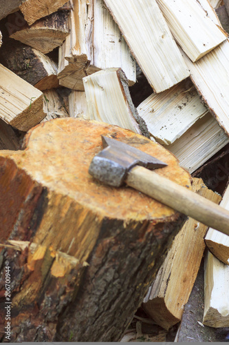 Chopped firewood. The ax with the wooden handle does not have a focus.