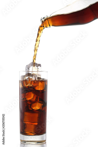 Pouring cola drink from bottle to glass with ice cubes on white background