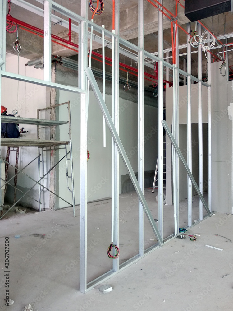 Drywall installation work in progress by construction workers at the