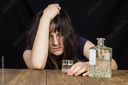 Canvastavla Drunk girl with a shot of alcohol and a bottle of alcohol, black background, woo