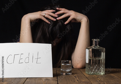Konstfotografi Brunette girl with a glass of vodka and a bottle, inscription on a sheet of cred