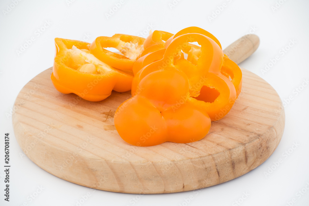 Freshness composition with orange bell pepper on cutting board isolated on white background
