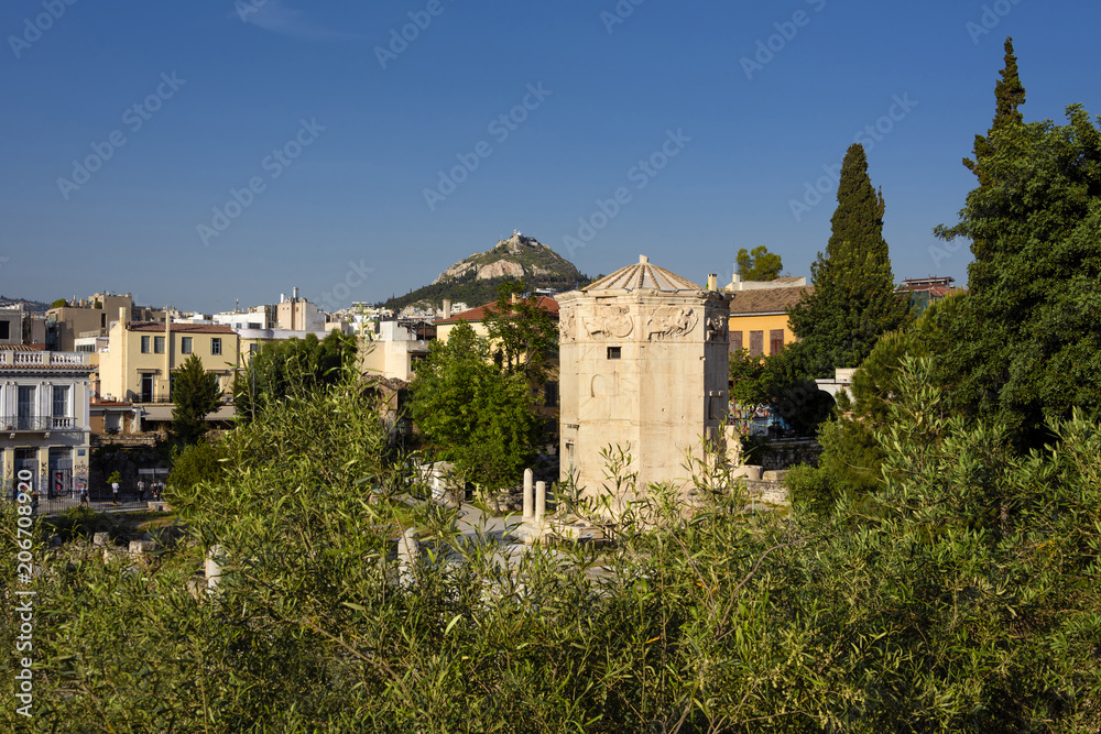Greece, Athens: Panoramic view of the Roman Agora field area in the city center of the Greek capital with famous Tower of the Winds, Mount Lycabettus hill, skyline and blue sky. April 25, 2018