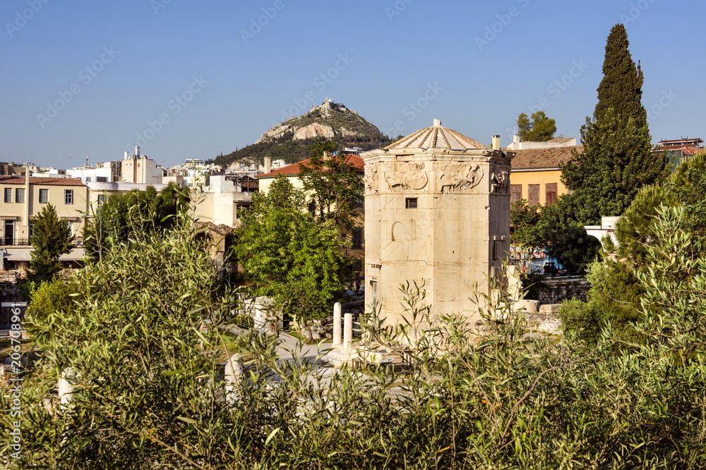 Greece, Athens: Panoramic view of the Roman Agora field area in the city center of the Greek capital with famous Tower of the Winds, Mount Lycabettus hill, skyline and blue sky in the background.