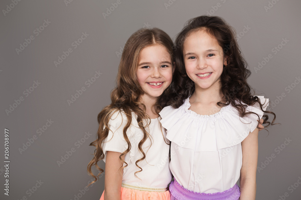 Happy small girls at gray studio background Happy small girls at gray studio background